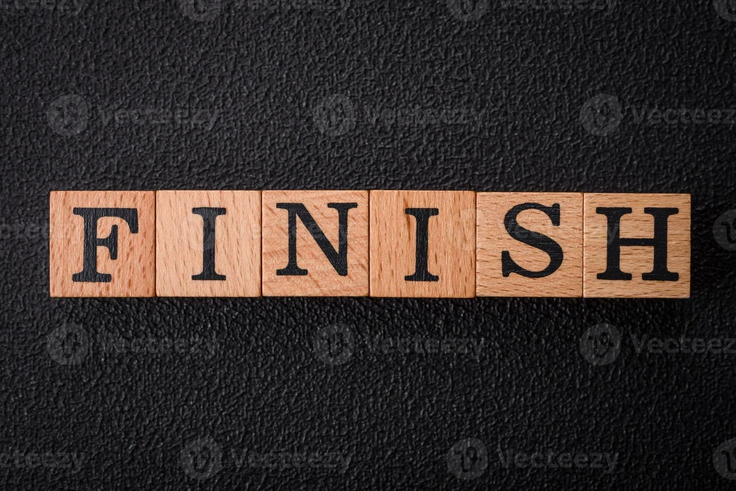 The inscription finish on wooden cubes on a dark concrete background photo