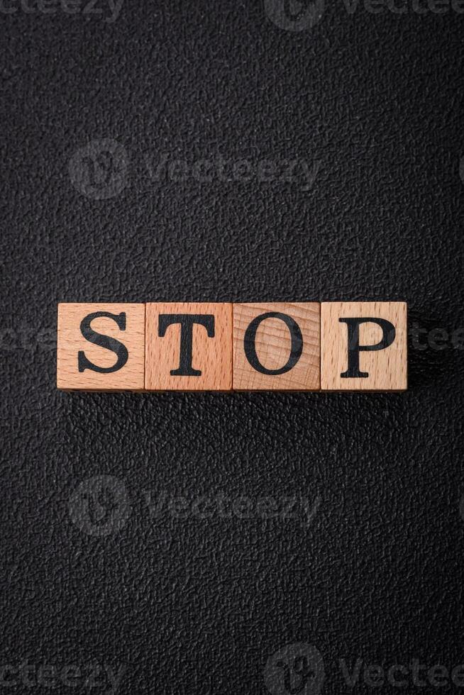 The inscription stop on wooden cubes on a dark concrete background photo