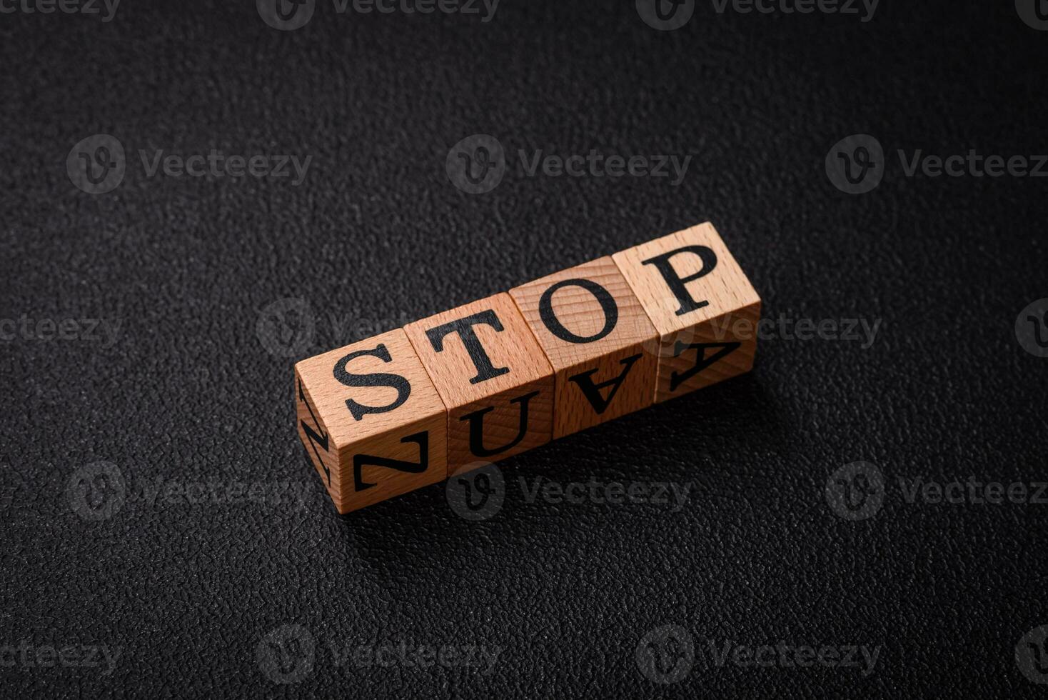 The inscription stop on wooden cubes on a dark concrete background photo