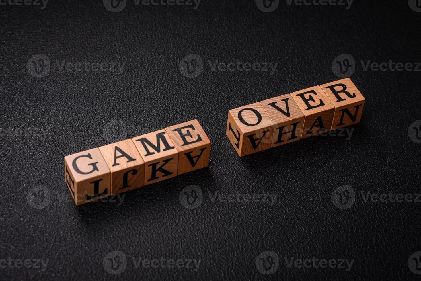 The inscription game over on wooden cubes on a dark concrete background photo