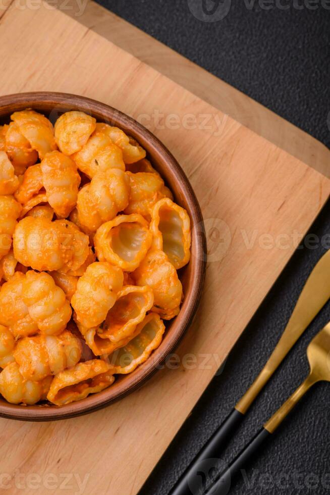 Delicious fresh pasta with pesto sauce, salt, spices and herbs on a ceramic plate photo