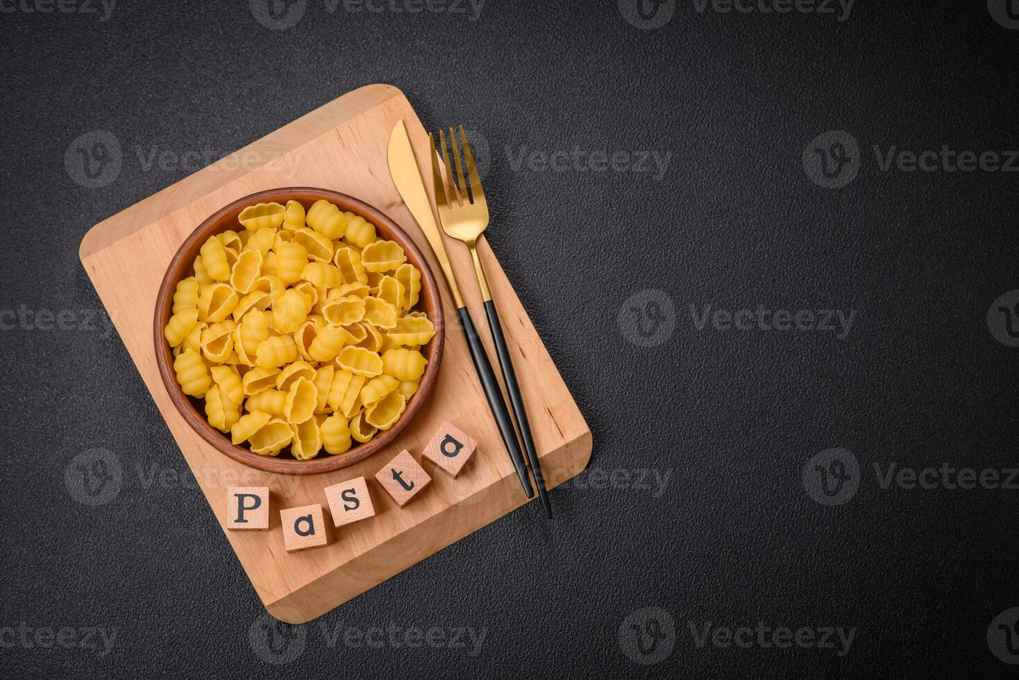 Raw durum wheat gnocchi pasta with salt and spices in a ceramic plate photo