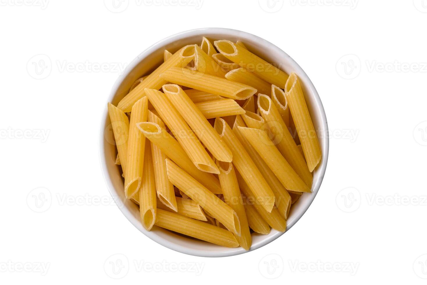 Raw penne pasta from whole grain wheat varieties with salt and spices photo