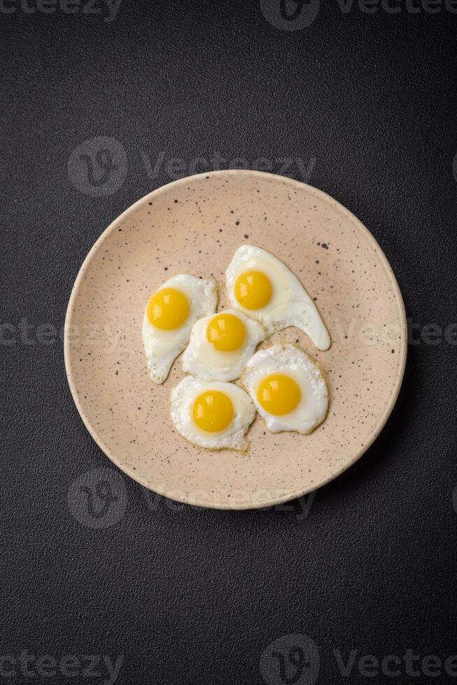 Delicious nutritious breakfast of fried quail eggs, bacon, legumes and cherry tomatoes photo