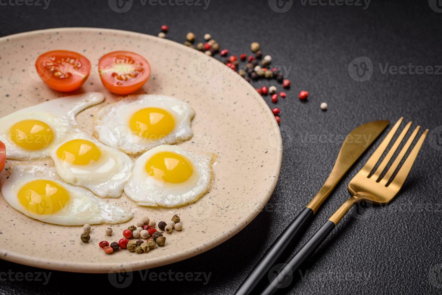 Delicious nutritious breakfast of fried quail eggs, bacon, legumes and cherry tomatoes photo