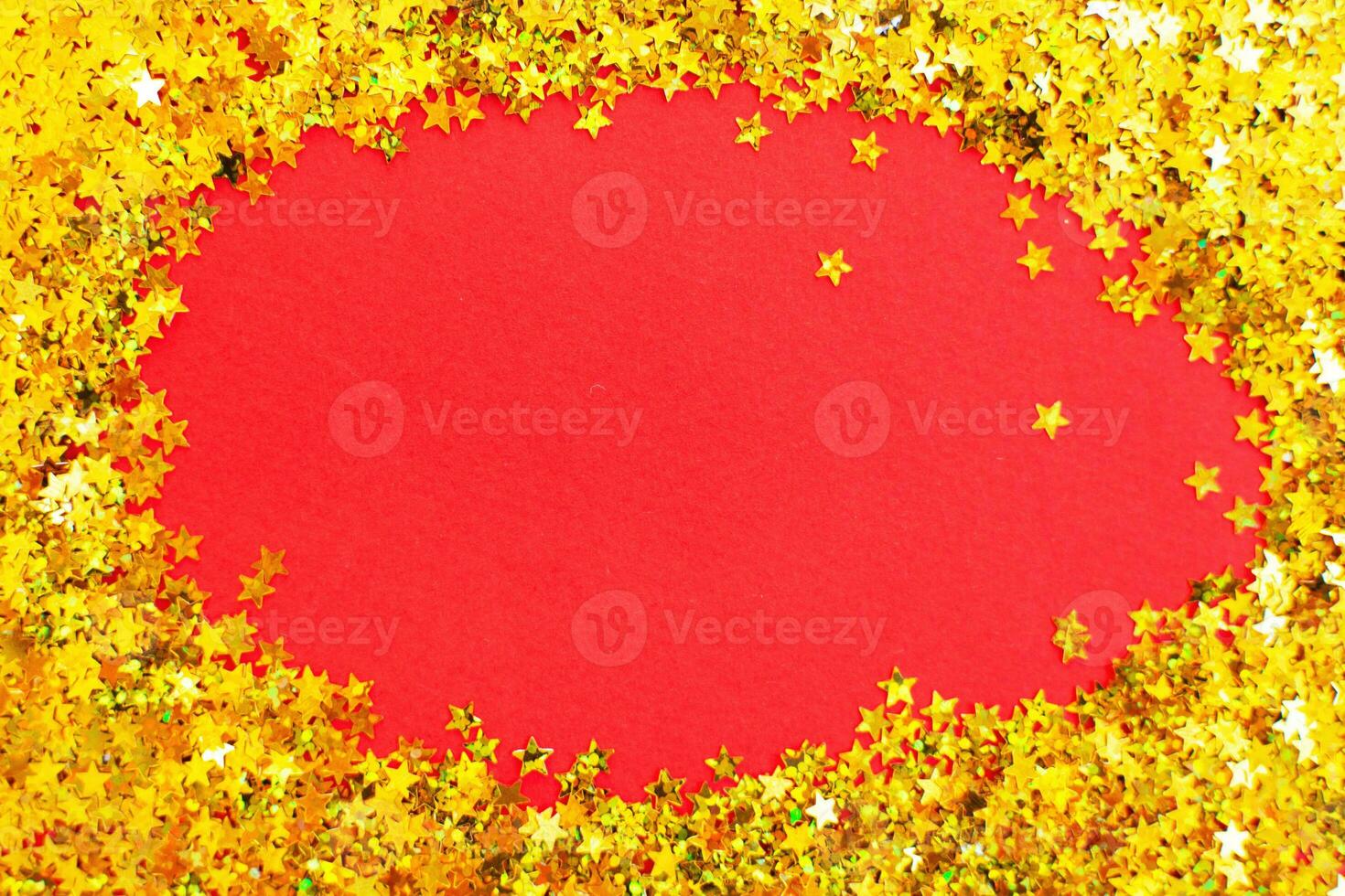 christmas shiny red background with festive golden confetti like a frame with copy space for text. photo