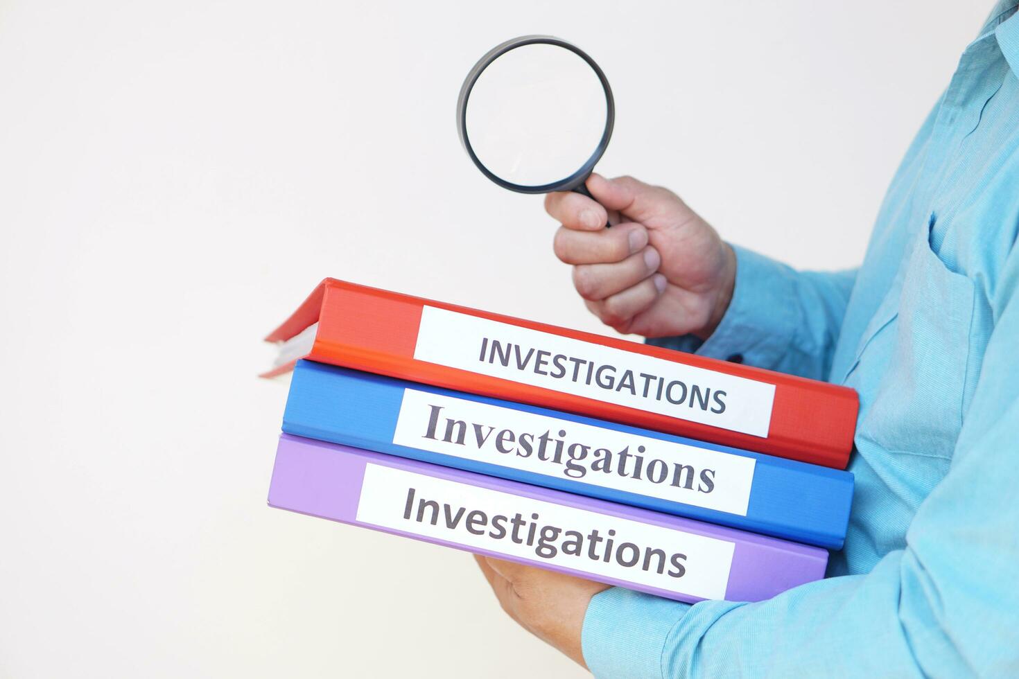 Close up a detective officer holds investigation folders and magnifying glass. Concept, crime. Analyzing criminal investigation. photo