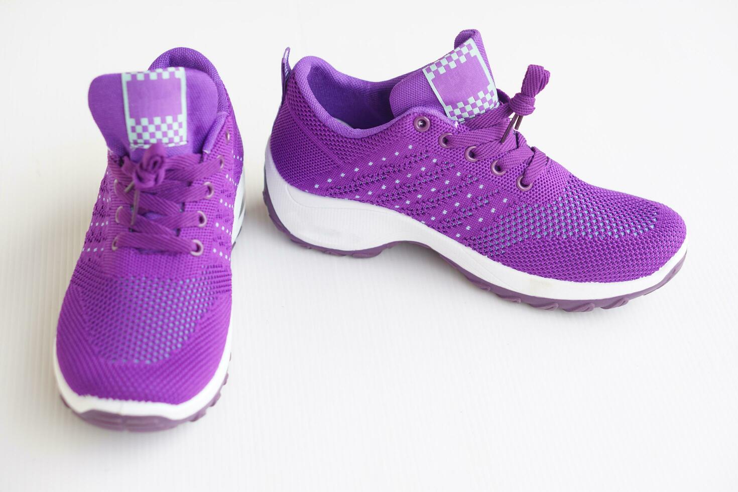 Pair of new purple sneakers. Fashionable and comfortable sport footwears. White background. Concept, shoes for doing sport or exercise, also can wear for traveling, hiking. photo