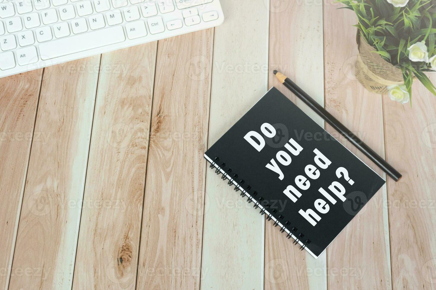 Word DO YOU NEED HELP on notepad on wooden desk. photo