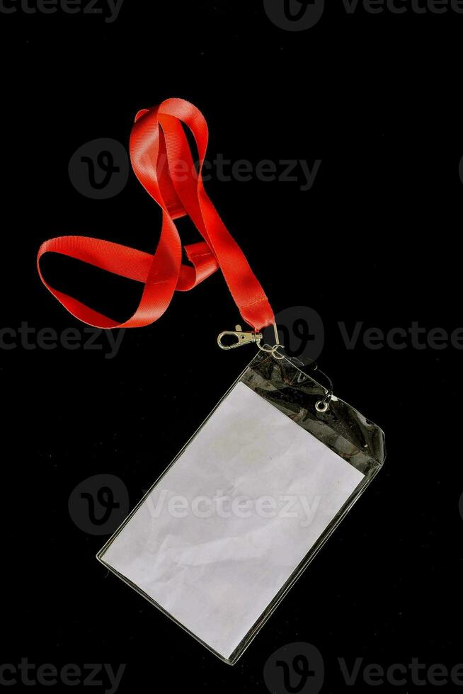 a white badge attached to a red lanyard photo