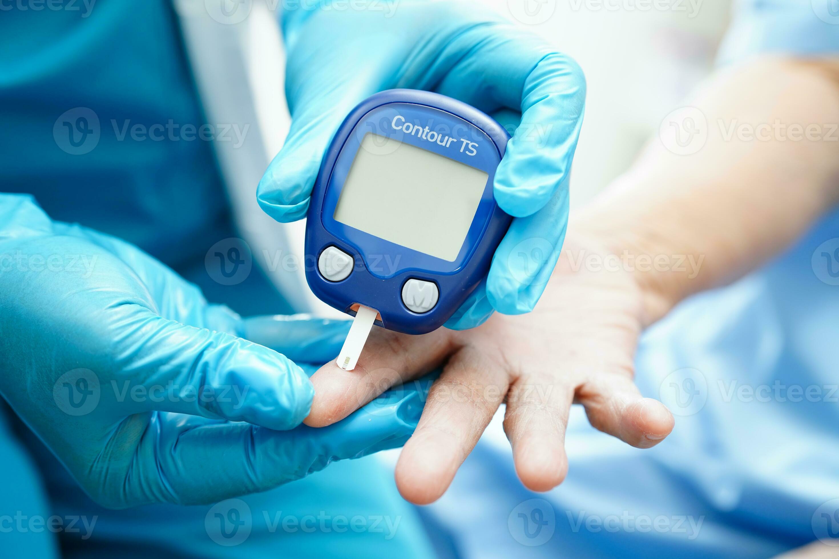 Asian doctor using digital glucose meter for check sample blood sugar