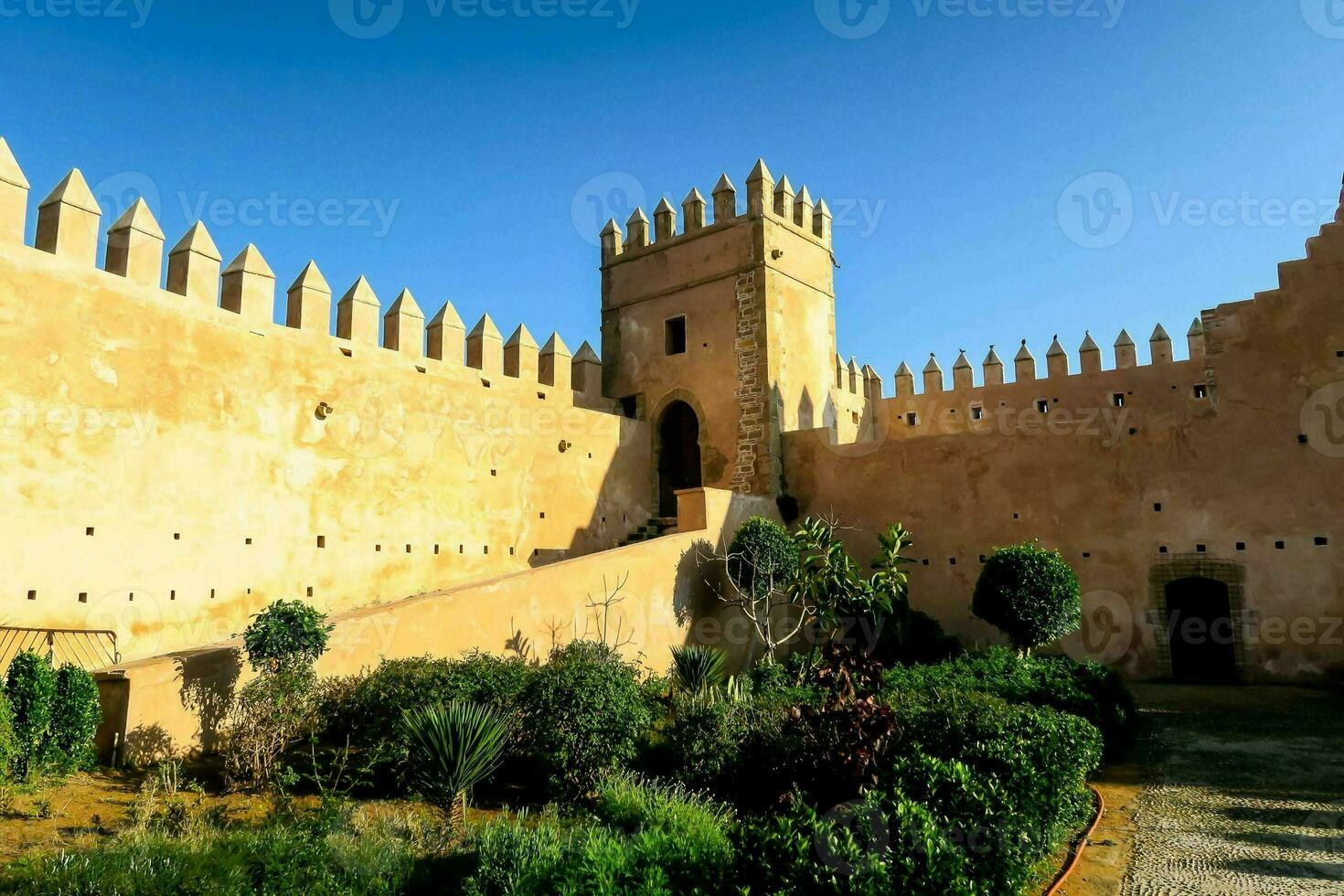 the castle walls are made of stone and have many turrets photo