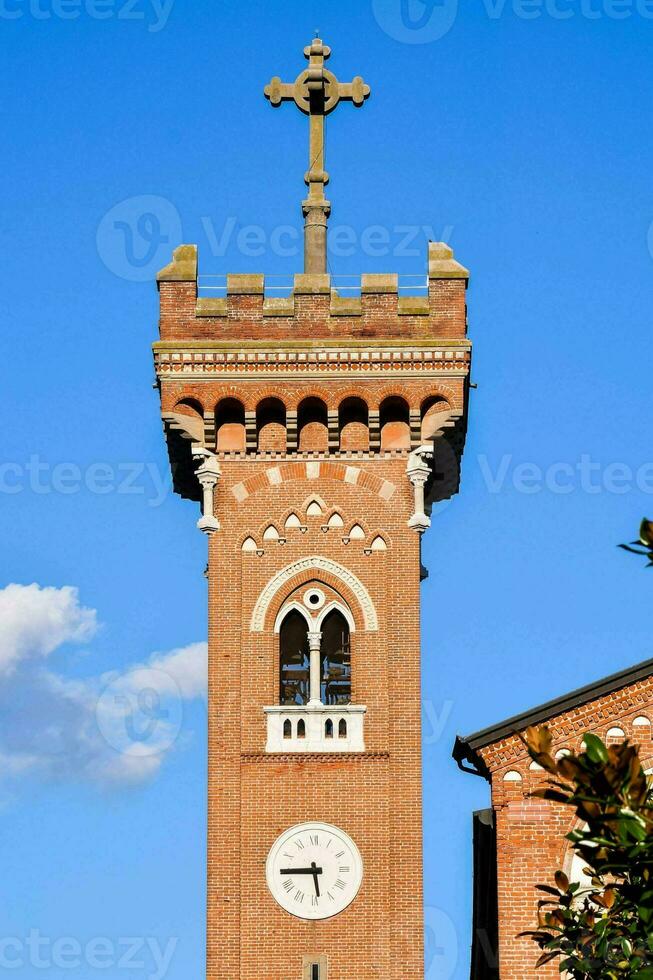 un reloj torre con un cruzar en parte superior foto