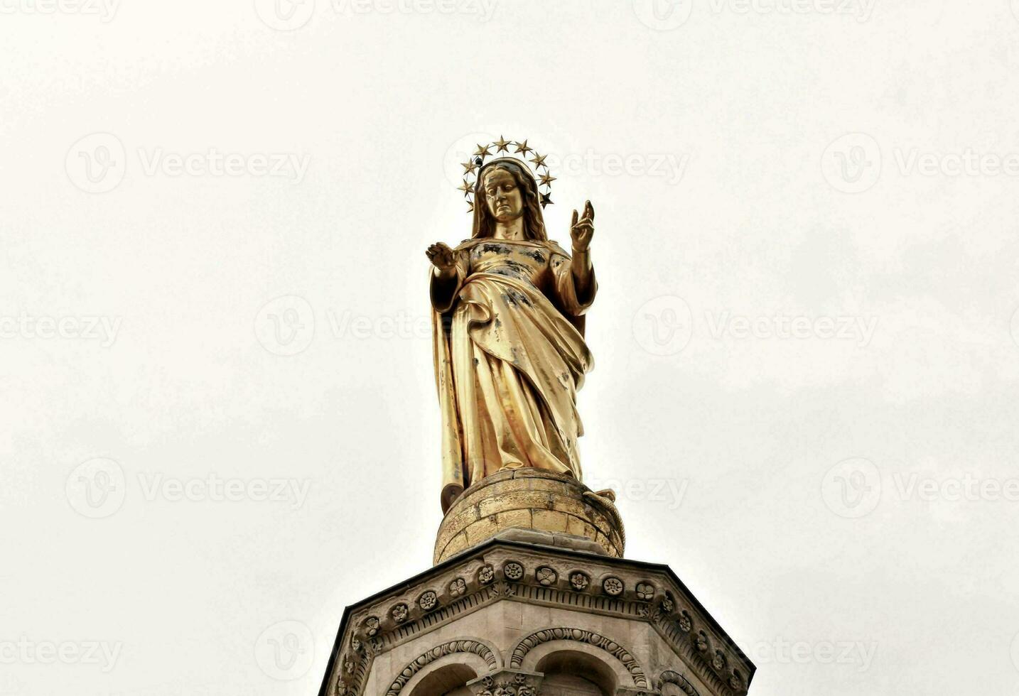 a statue of mary on top of a building photo