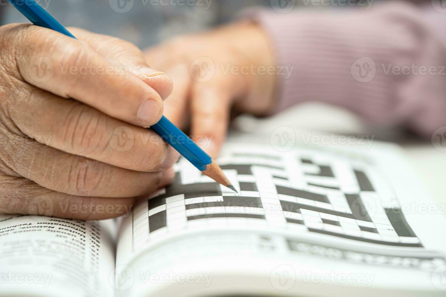 Alzheimer disease AD, Asian elderly woman playing sudoku puzzle game to practice brain training for dementia prevention. photo