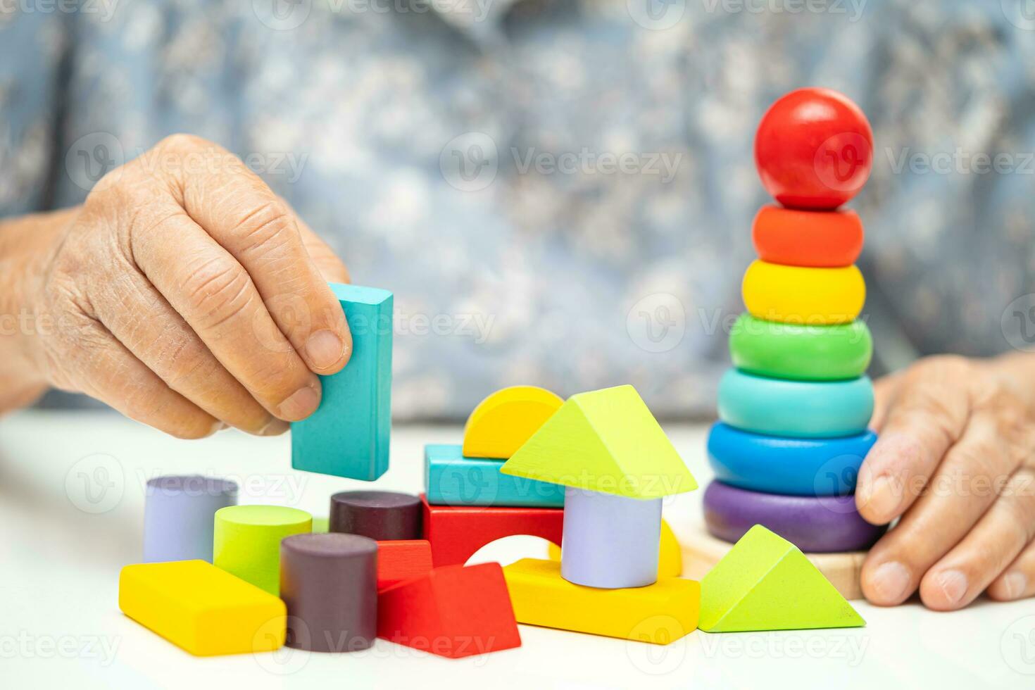 Alzheimer disease AD, Asian elderly woman patient suffering from dementia learn practical motor skills rehabilitation. photo