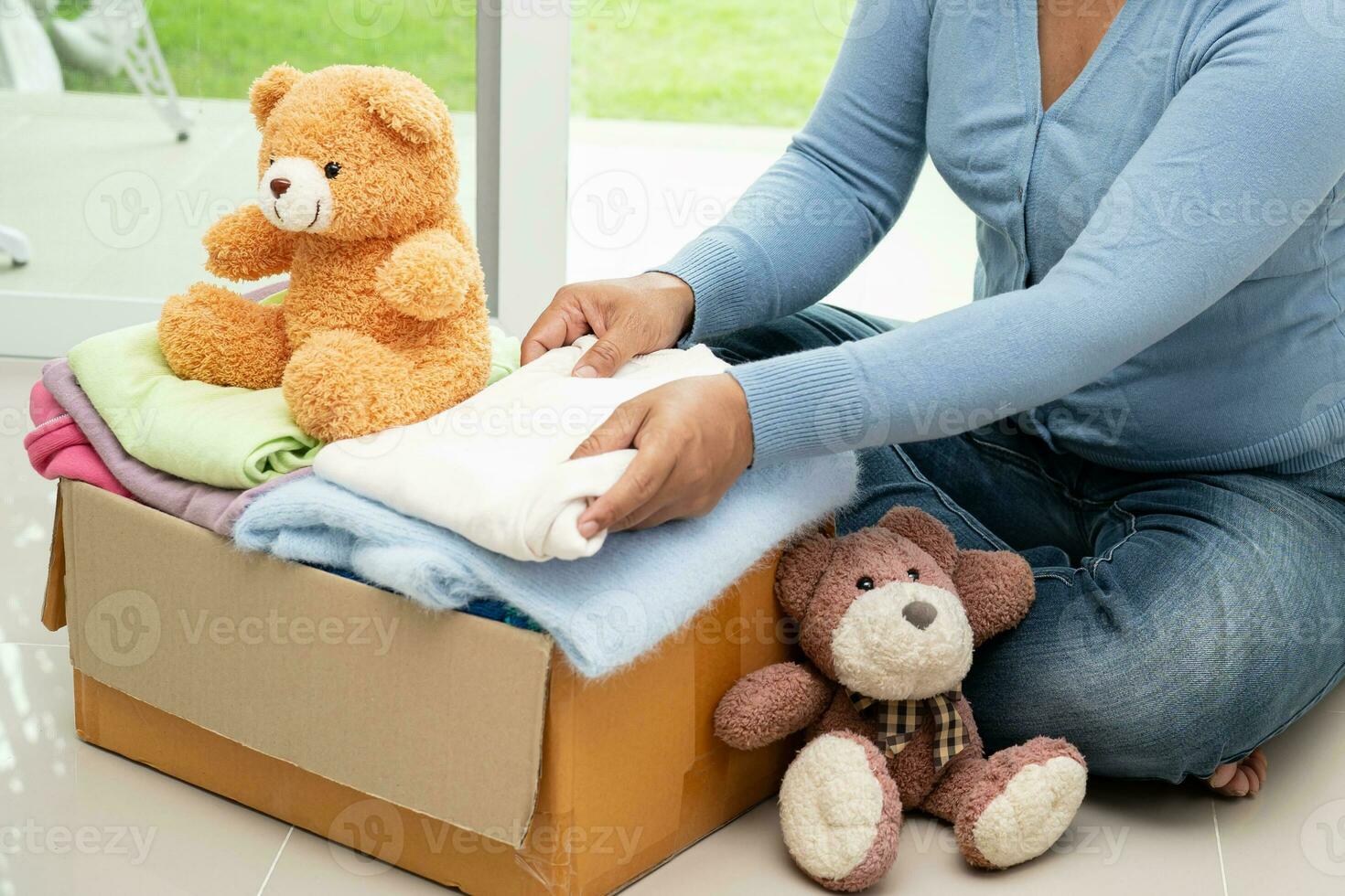 Donation box with used clothes and doll at home to support help for poor people in the world. photo