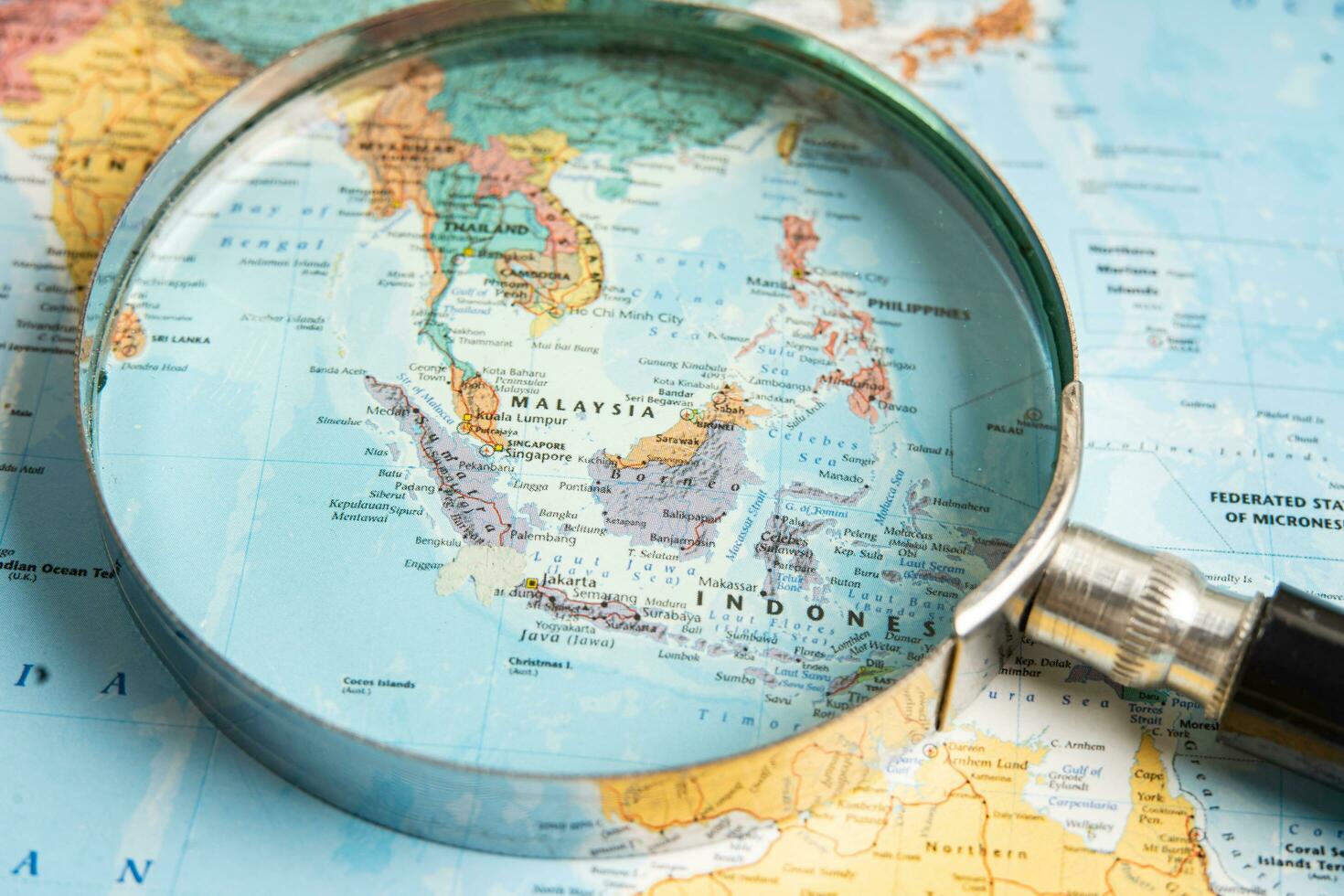 Bangkok, Thailand  January 20, 2022 Asia, Magnifying glass close up with colorful world map, travel, geography, tourism and exploration concept. photo