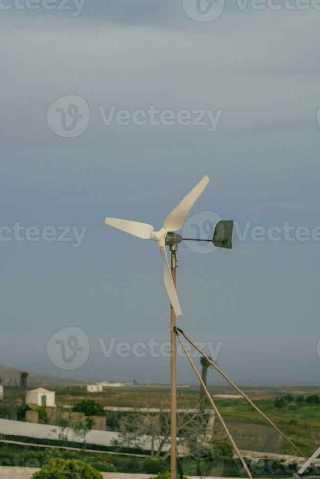 Vertical shot of small residential wind turbine electricity generator for off-grid usage photo