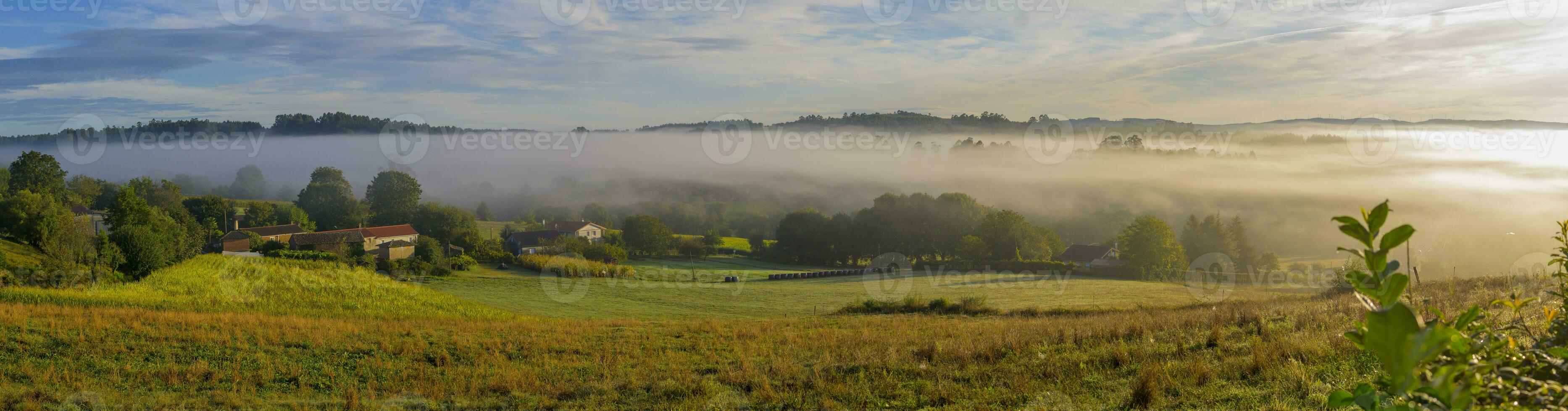 View on a farm and surrounding fields during sunrise on the pilgrimage hike Camino Santiago photo