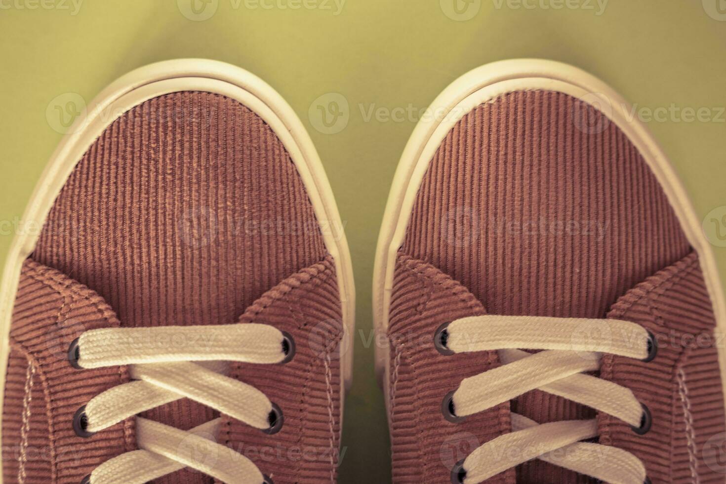 Beige corduroy sneakers on a yellow background photo