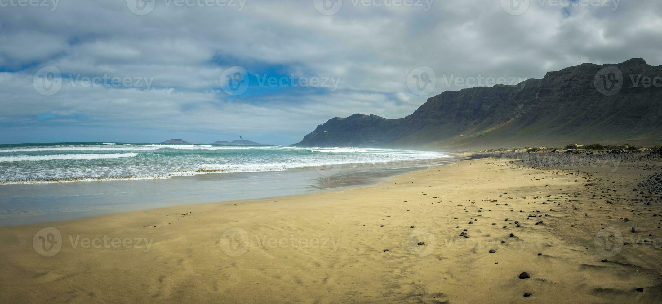 View on Famara beach on the Canary Island of Lanzarote, with some windsurfing in the far distance photo