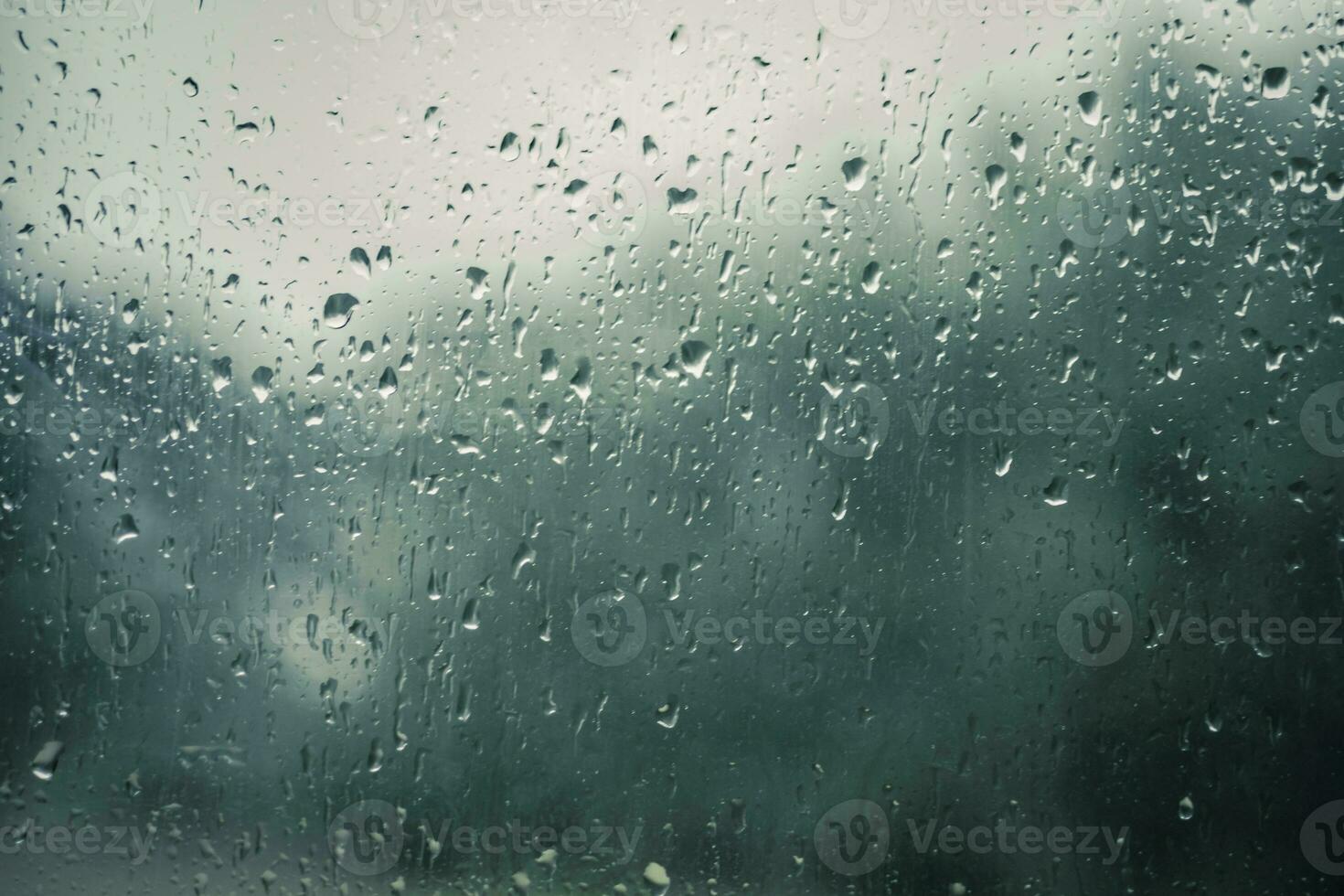 Rain drops on a window with blurry background photo