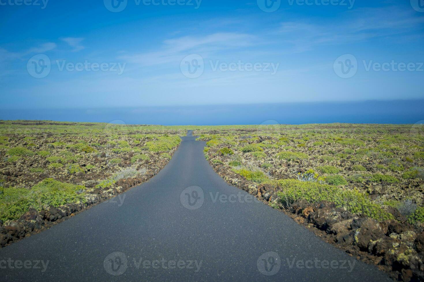 Empty and deserted road through volcanic landscape on Lanzarote, one of the Canary Islands of Spain photo