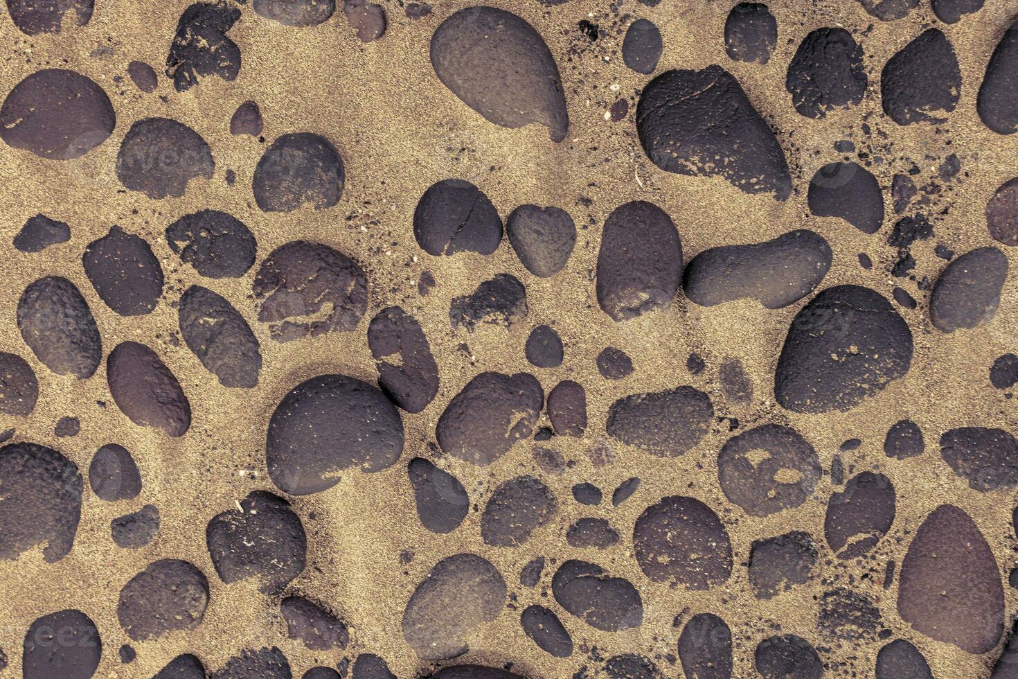 Directly above shot of lava stones in the sand photo