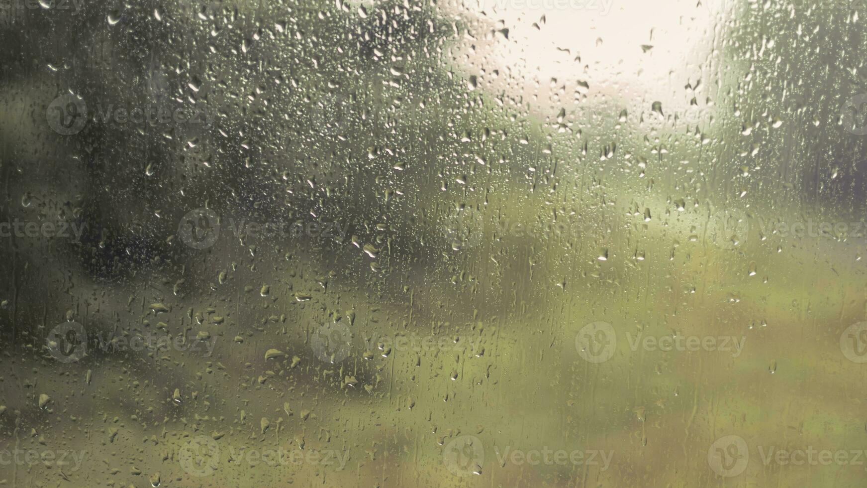 Rain drops on a window with blurry background photo