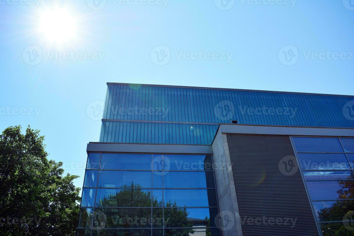 Glass building with transparent facade of the building and blue sky. Structural glass wall reflecting blue sky. Abstract modern architecture fragment. Contemporary architectural background. photo