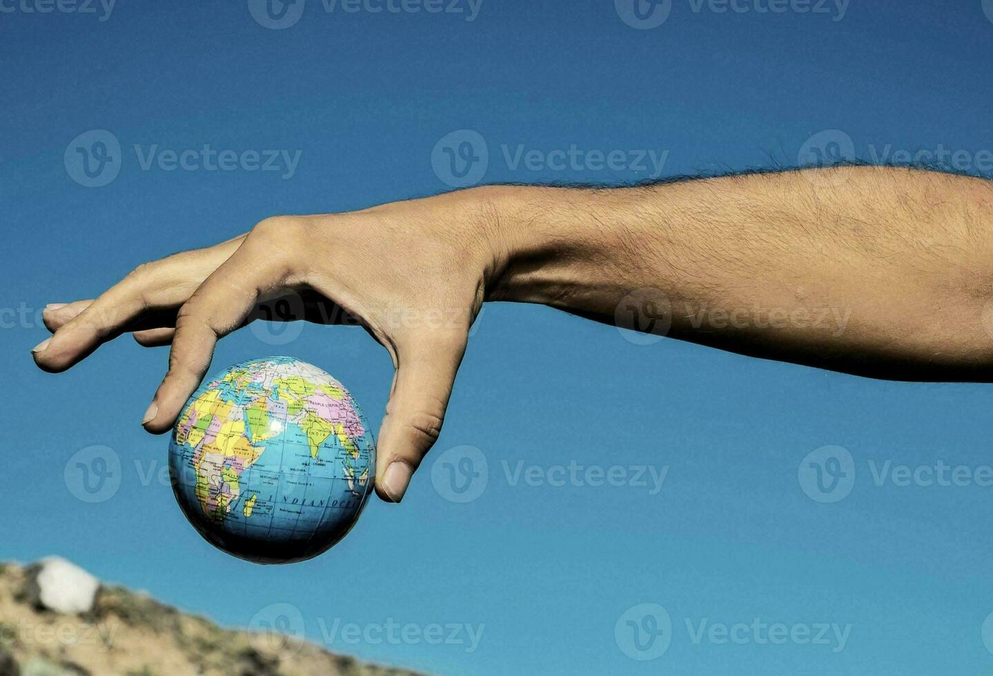 a person holding a small globe in their hand photo