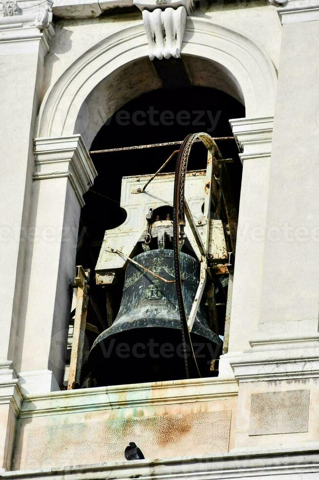 a large bell is sitting in the window of a building photo