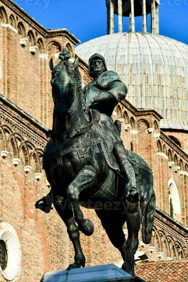 statue of a person riding a horse in front of the cathedral photo