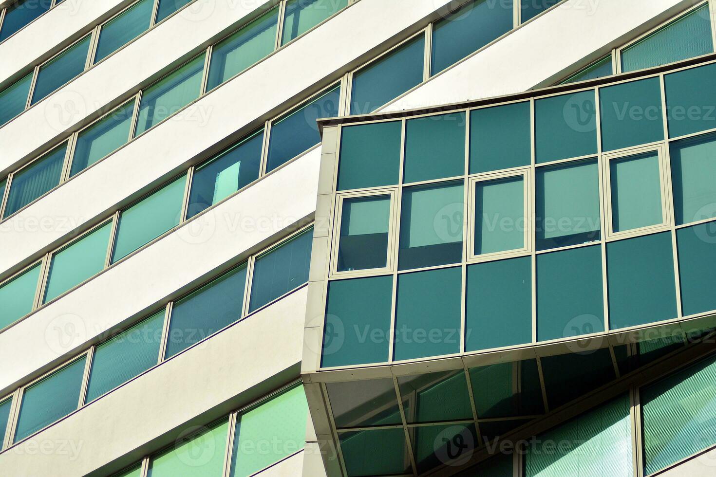 vaso edificio con transparente fachada de el edificio y azul cielo. estructural vaso pared reflejando azul cielo. foto