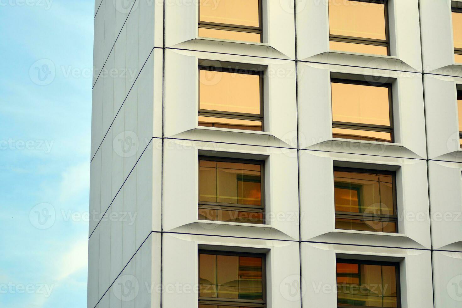 moderno oficina edificio en el ciudad con ventanas y acero y aluminio paneles pared. contemporáneo comercial arquitectura, vertical convergente geométrico líneas. foto