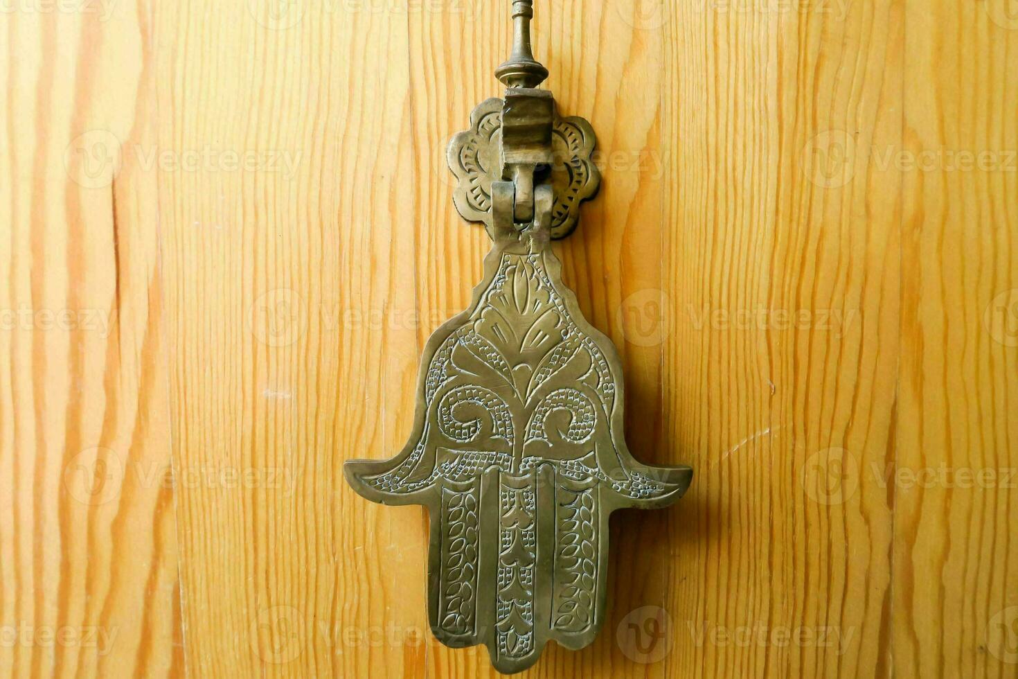 a hamsa hand hanging on a wooden door photo