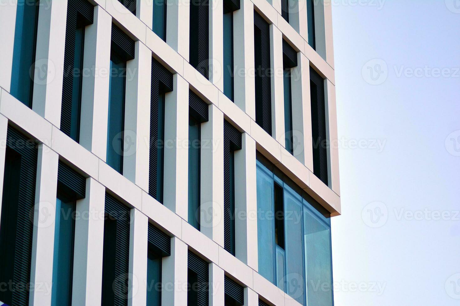 Modern office building in the city with windows and  steel and aluminum panels wall. Contemporary commercial architecture, vertical converging geometric lines. photo