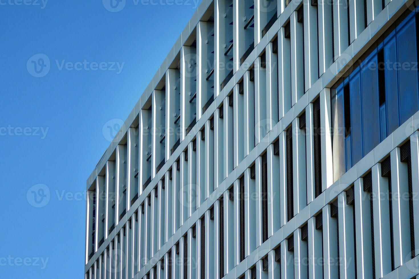 Modern office building in the city with windows and  steel and aluminum panels wall. Contemporary commercial architecture, vertical converging geometric lines. photo