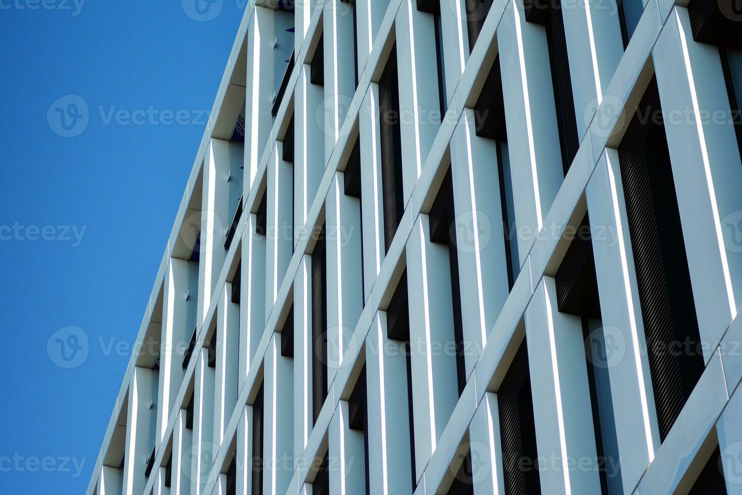 Modern office building in the city with windows and  steel and aluminum panels wall. Contemporary commercial architecture, vertical converging geometric lines. photo