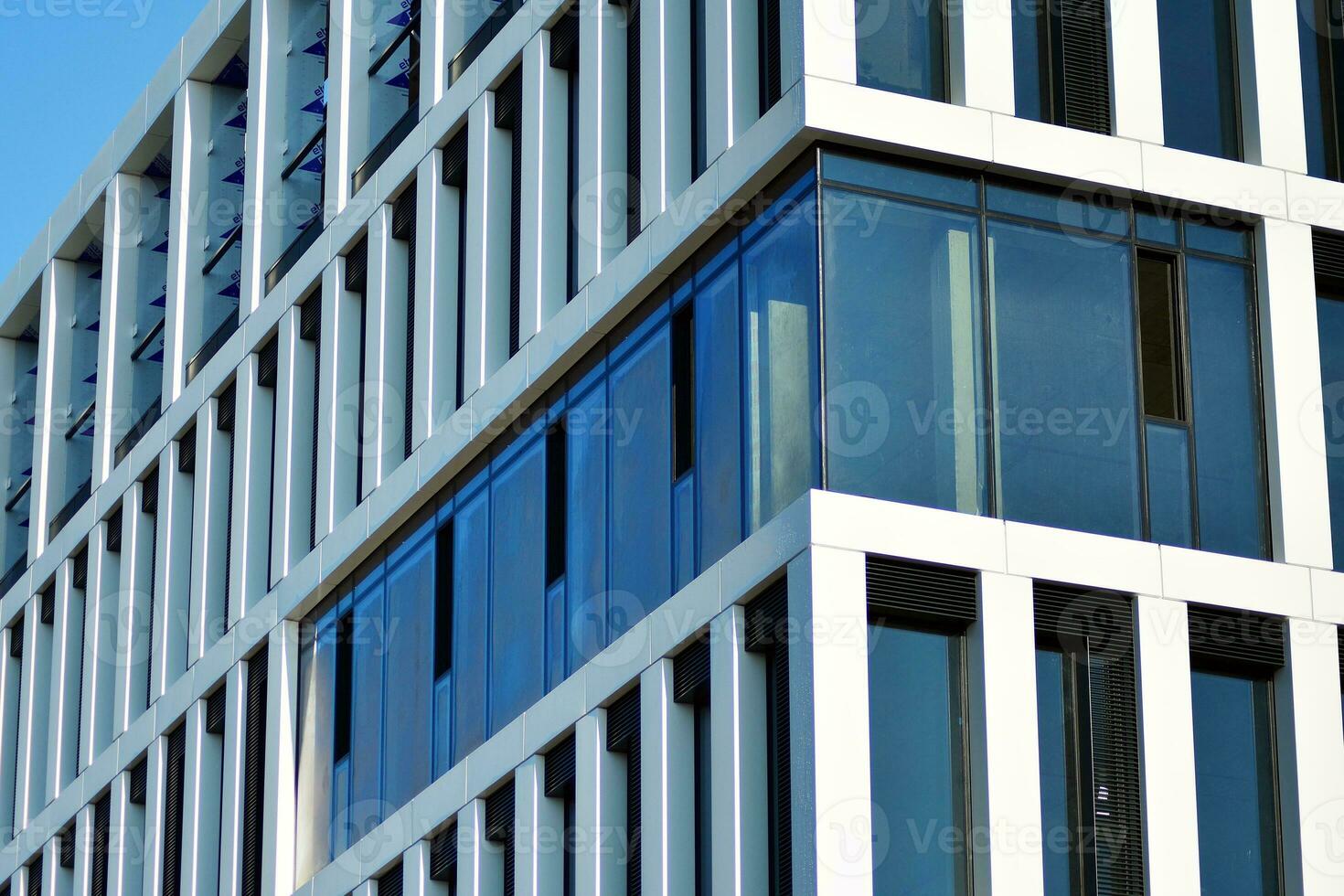 Modern office building in the city with windows and  steel and aluminum panels wall. Contemporary commercial architecture, vertical converging geometric lines. photo