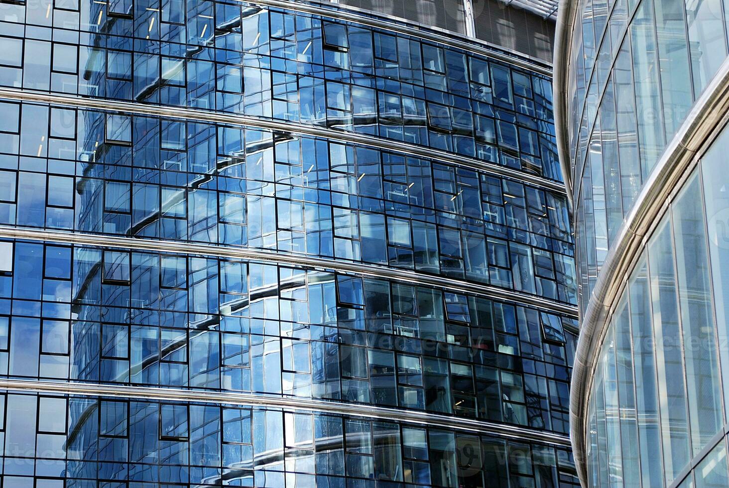 Glass building with transparent facade of the building and blue sky. Structural glass wall reflecting blue sky. Abstract modern architecture fragment. Contemporary architectural background. photo