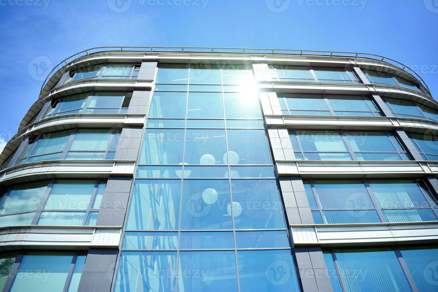 Glass building with transparent facade of the building and blue sky. Structural glass wall reflecting blue sky. Abstract modern architecture fragment. Contemporary architectural background. photo