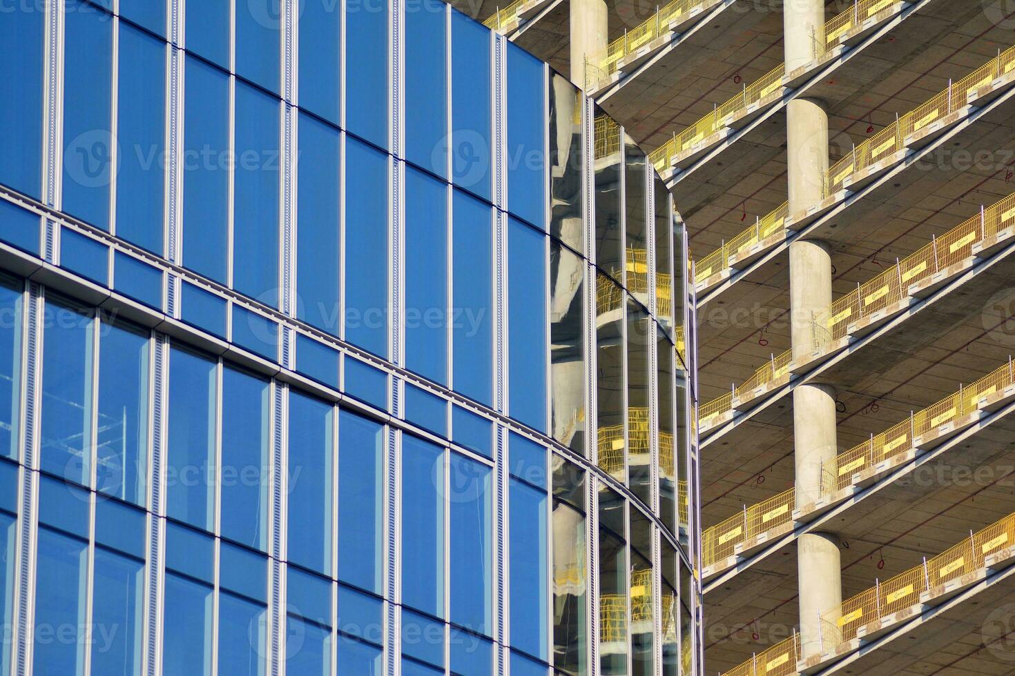 Glass building with transparent facade of the building and blue sky. Structural glass wall reflecting blue sky. Abstract modern architecture fragment. Contemporary architectural background. photo