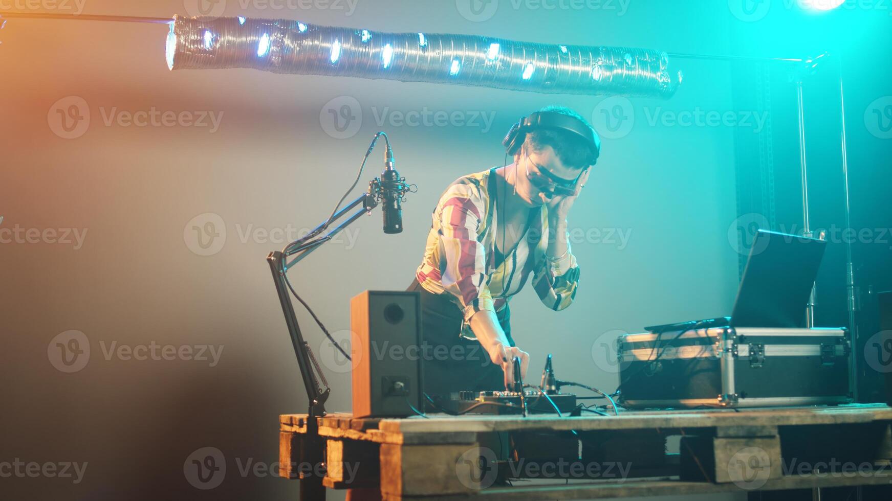 Woman artist mixing sounds at club party with dj turntables, using audio devices to play music and create modern remix at stereo. Having fun with disco equipment, nightclub. Handheld shot. photo