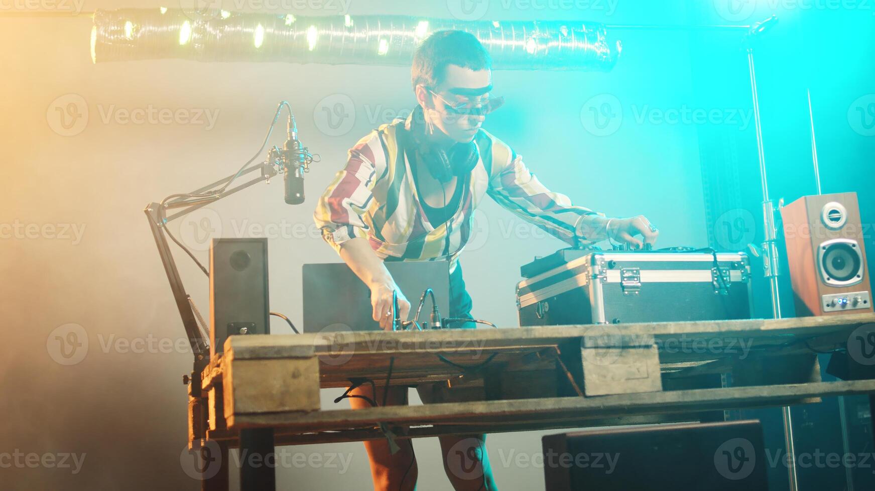 Woman artist mixing records and vinyl for disco tunes, having fun with disc mixing turntables for modern clubbing event. Funky musician using audio dj instruments to play techno songs. Handheld shot. photo