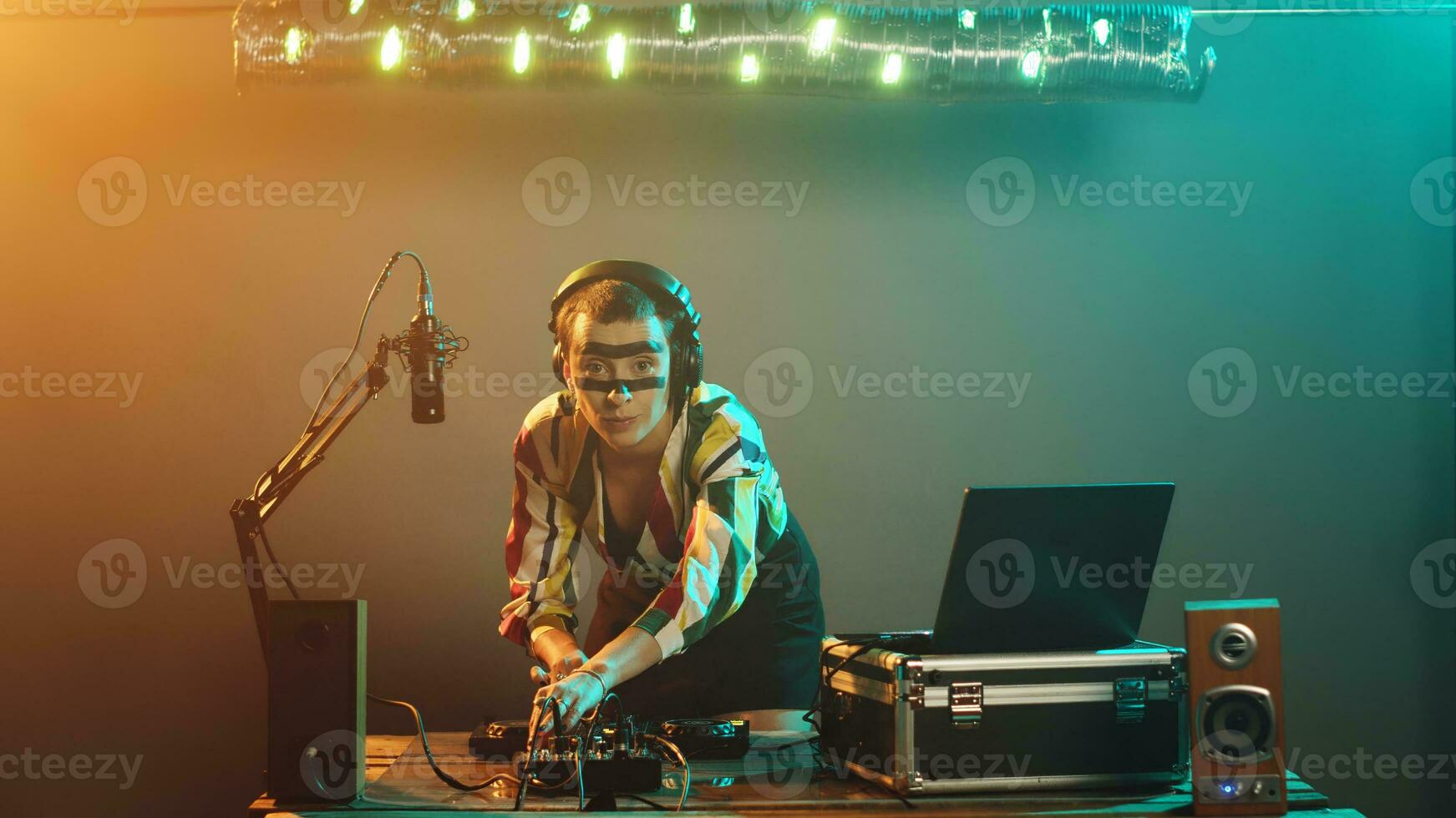 mujer artista mezcla techno canciones en audio botones, teniendo divertido con tocadiscos jugando moderno música a Club nocturno fiesta. joven ejecutante pruebas bajo controlar llave, ajustar volumen. trípode disparo. foto