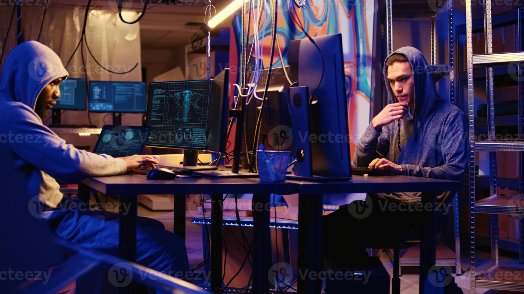 Panning shot of hackers working hard on writing lines of code on hideout computers, trying all methods of getting past security systems. Professional scammers building scripts that can hack devices photo