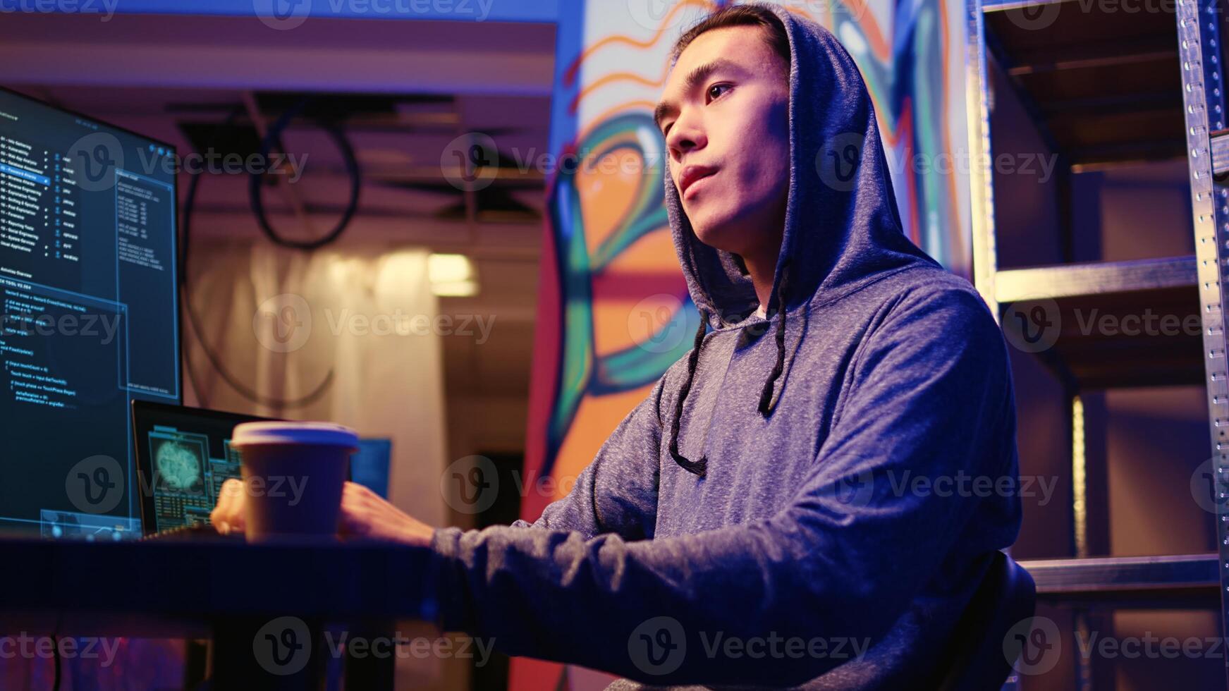 Asian hacker in underground base getting past anti tamper measures implemented by companies trying to protect their products. Cracker trying to pirate software and video game releases, zoom in shot photo