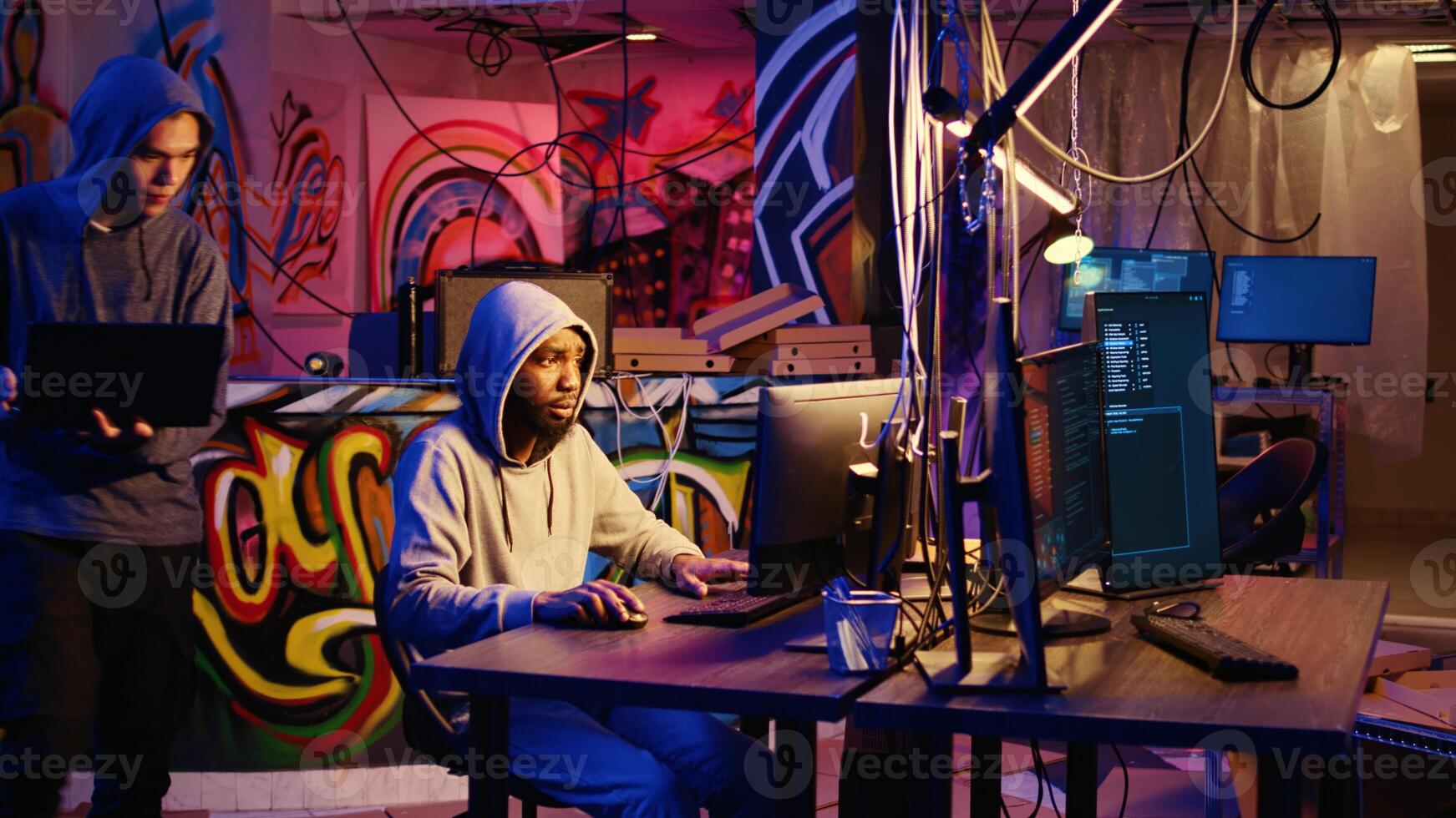 Hacking group leader teaching new member how to code malware designed to exploit network backdoors. Script kiddie learns how to bypass security measures such as logins and password protections photo